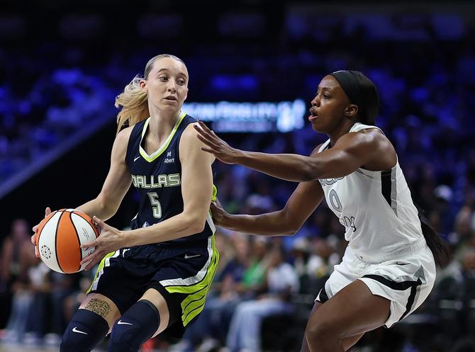 Paige Bueckers handling the basketball against Las Vegas Ace Jackie Young