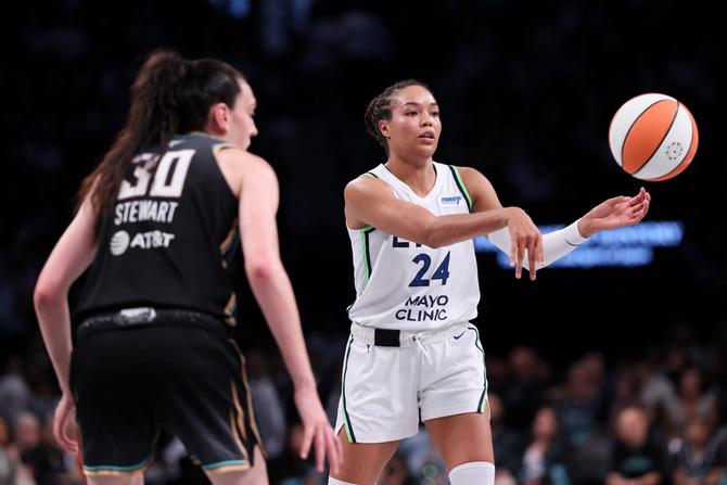 Napheesa Collier of the Minnesota Lynx passes the ball while defended by Breanna Stewart of the New York Liberty.