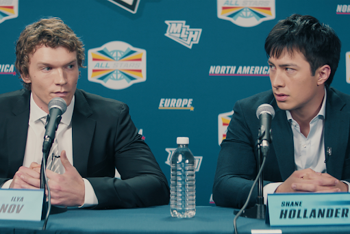 Heated Rivalry characters Ilya Rozanov (played by Connor Storrie) and Shane Hollander (played by Hudson Williams) speak at a press conference.