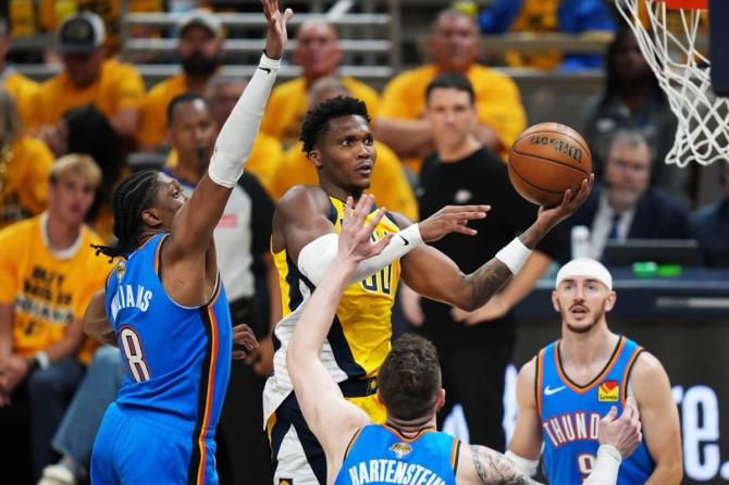 Indiana Pacer Bennedict Mathurin drives to the basket against two Oklahoma City Thunder defenders.