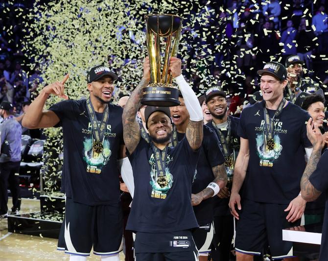 Giannis Antetokounmpo #34, Damian Lillard #0 and Brook Lopez #11 of the Milwaukee Bucks celebrate with the championship trophy after the Bucks defeated the Oklahoma City Thunder 97-81 to win the championship game of the Emirates NBA Cup at T-Mobile Arena