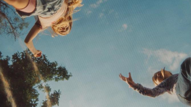 Two children are pictured with a blue sky in the background