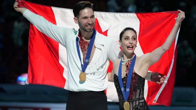 Deanna Stellato-Dudek and Maxime Deschamps hold up the Canadian flag while posing with their gold medals following the victory ceremony for the pairs competition at the ISU World Figure Skating Championships