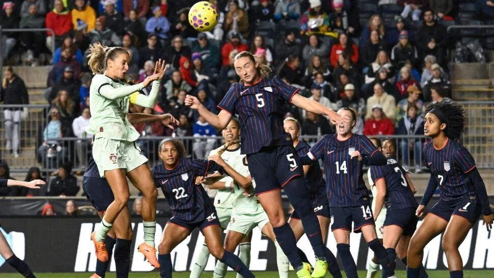 USWNT heads the ball away.