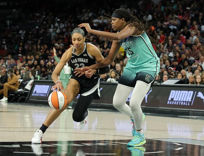 The Las Vegas Aces’ A’ja Wilson drives to the basket while being defended by the NY Liberty’s Jonquel Jones.