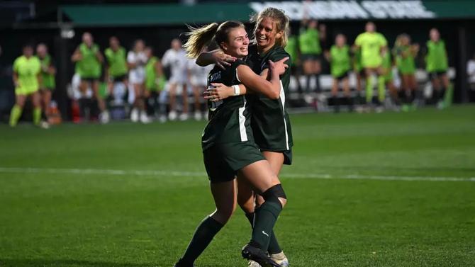 Members of the Michigan State women’s soccer team celebrate a goal.