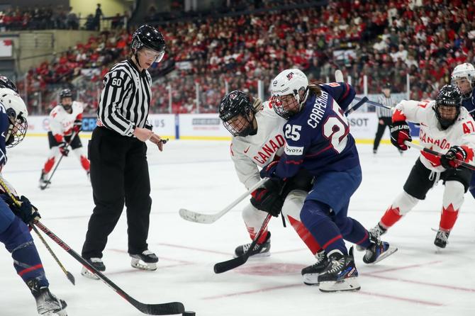 Canada forward Natalie Spooner battles for the puck against USA forward Alex Carpenter during the gold medal game of the 2023 IIHF Women's World Championship.
