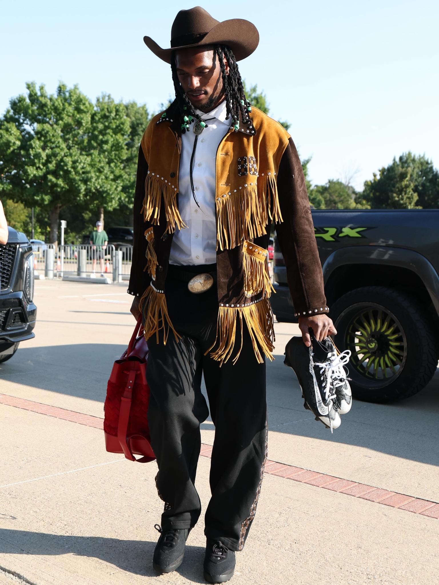 Dallas Cowboys wide receiver CeeDee Lamb walks into the stadium in a Western-inspired outfit.