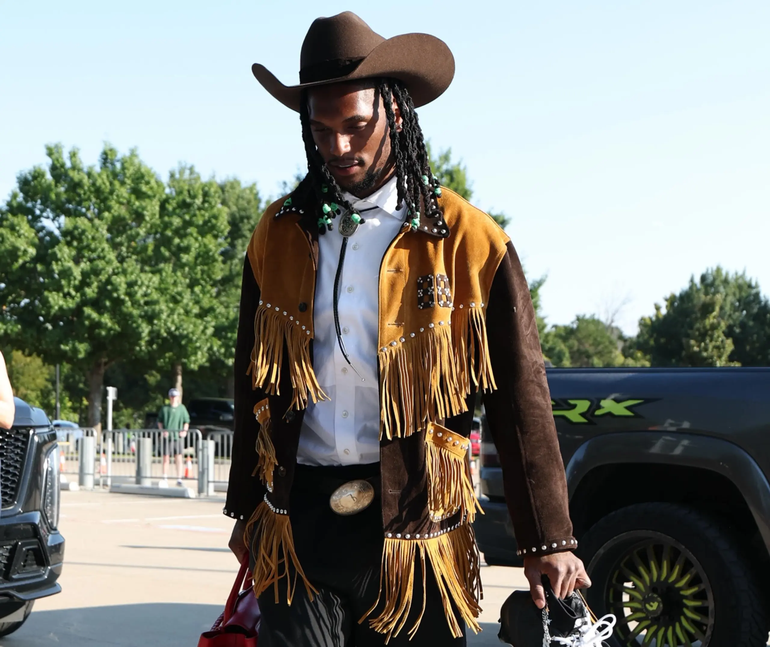 Dallas Cowboys wide receiver CeeDee Lamb walks into the stadium in a Western-inspired outfit.