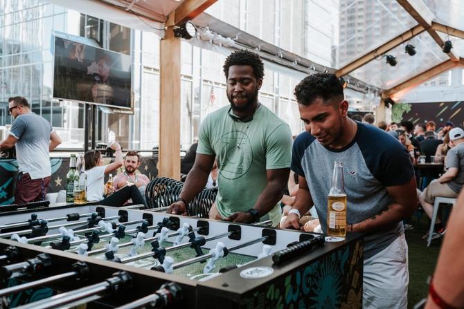 Soccer fans play foosball at the Hangar Lounge at the FOX Sports House at the 2021 SXSW Festival in Austin, Texas.