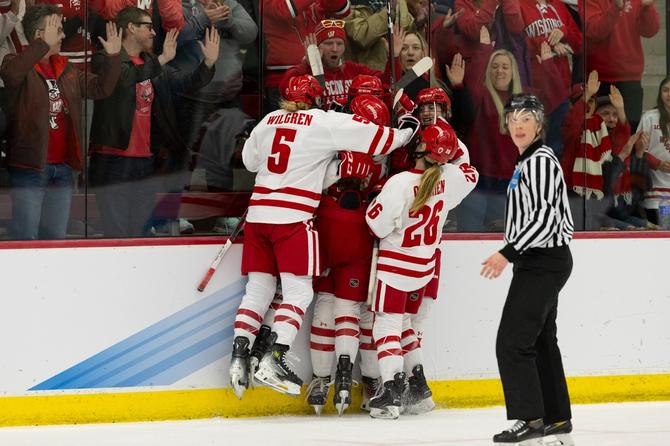 The University of Wisconsin women’s hockey team celebrates after a goal.