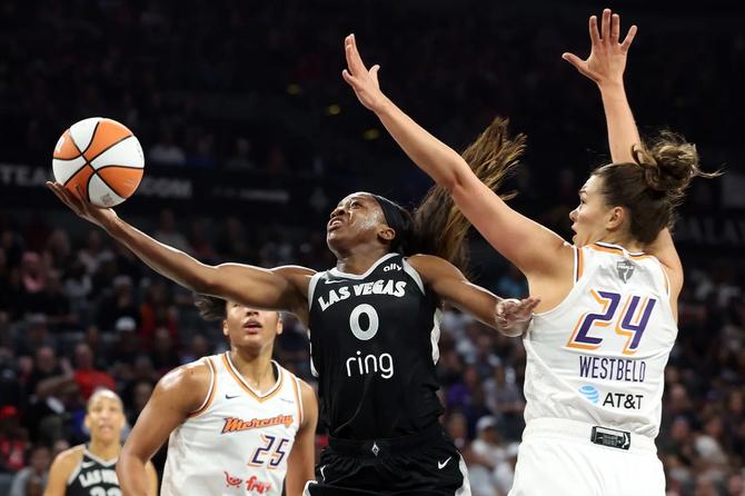 Las Vegas Aces guard Jackie Young finishes at the rim against the Phoenix Mercury’s Kathryn Westbeld.