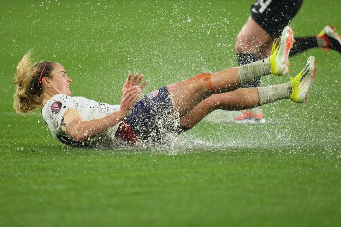 USWNT captain Lindsey Horan slides through a puddle.