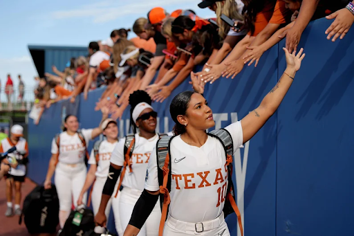 University of Texas softball players greet fans at a game.