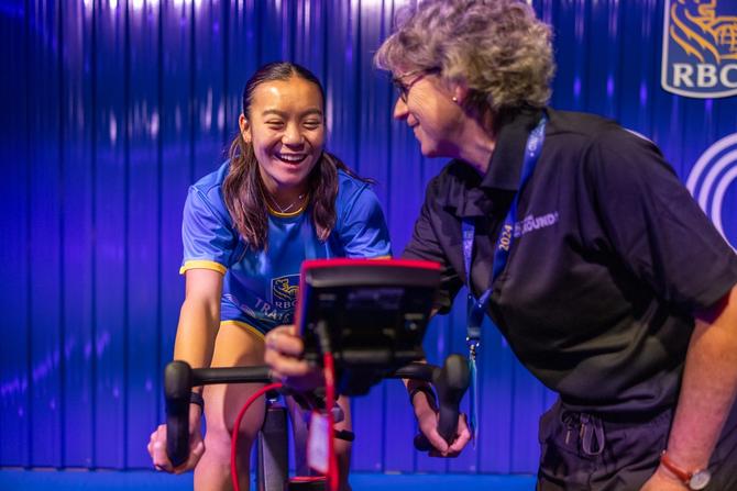 A young athlete competing at RBC Training Ground on a stationary bike