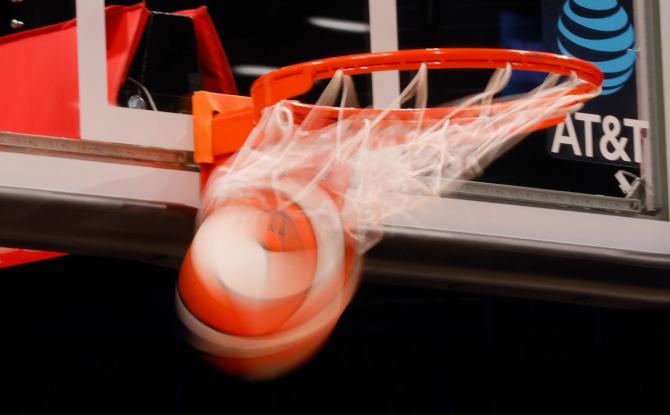 A WNBA ball swishes through the basket.