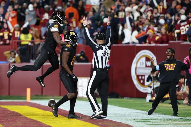 Washington Commanders wide receivers Terry McLaurin and Noah Brown celebrate in the endzone after scoring the game-winning touchdown.