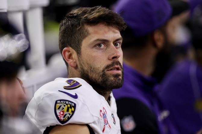Baltimore Ravens kicker Justin Tucker sits on the bench during a game.