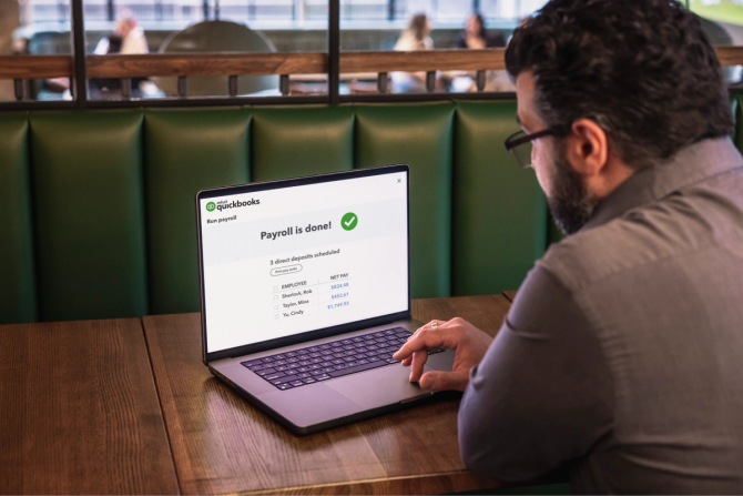 A man completing payroll on his laptop