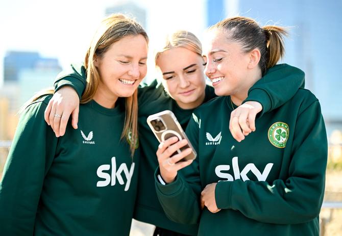 Republic of Ireland players, from left, Kyra Carusa, Izzy Atkinson, and Abbie Larkin review their TikTok dance recording at the Elizabeth Quay Bridge in Perth, Australia, ahead of their second Group B match of the FIFA Women's World Cup 2023, against Canada.