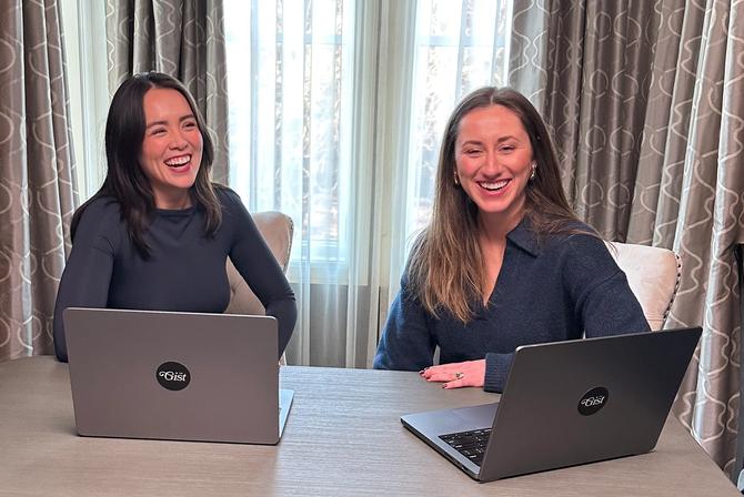The GIST co-founders Jacie and Ellen smiling while sitting at a desk