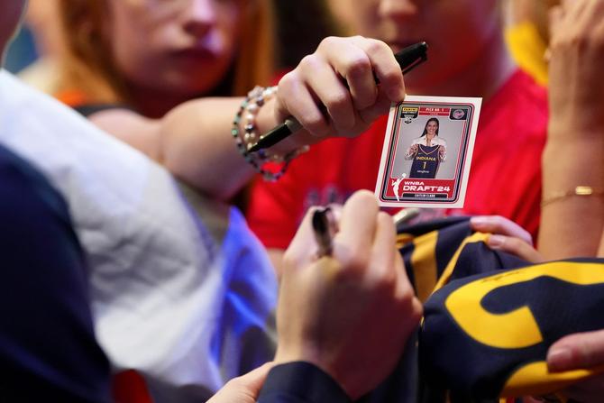 A close up view of a Caitlin Clark trading card being passed during an autograph session after the Indiana Fever played the Dallas Wings.