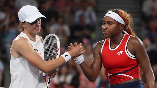 Iga Świątek and Coco Gauff grimace while shaking hands at a United Cup match.