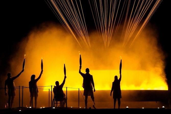Paralympic athletes pose with lit torches during the 2024 Paralympics Opening Ceremony in Paris, France.