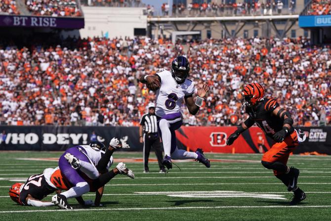 Baltimore Raven Lamar Jackson runs the ball in an attempt to evade Cincinnati Bengal Sam Hubbard during the first quarter.