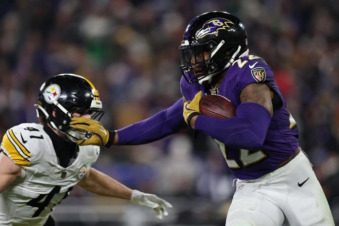 Baltimore Ravens running back Derrick Henry stiff arms Pittsburgh Steelers linebacker Payton Wilson.