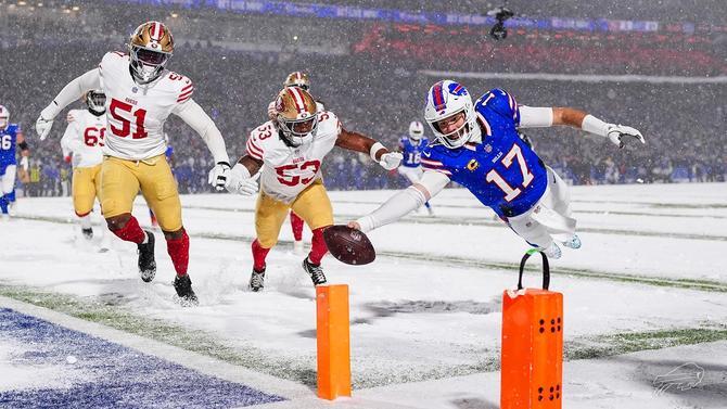 Buffalo Bills quarterback Josh Allen reaches for the endzone as he dives holding the football.