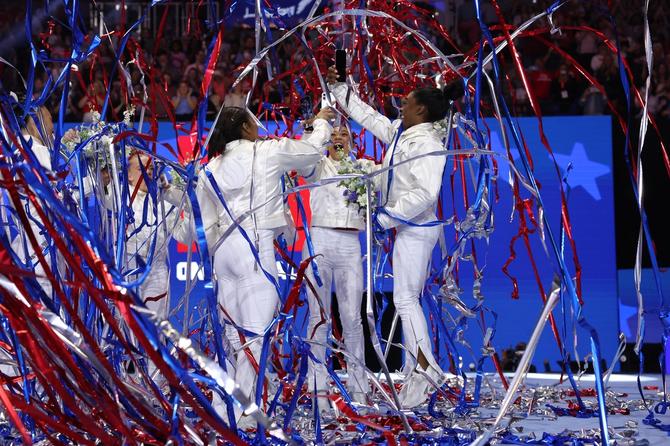 Jordan Chiles, Suni Lee, and Simone Biles celebrate as red, white, and blue streamers fall after being selected for the 2024 U.S. Olympic Women's Gymnastics Team.