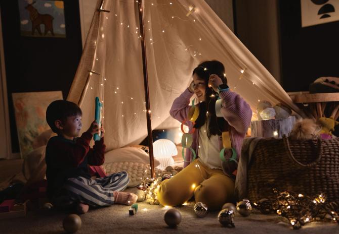Two kids playing together in their homemade fort