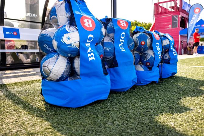 Bags of soccer balls lined up on the field