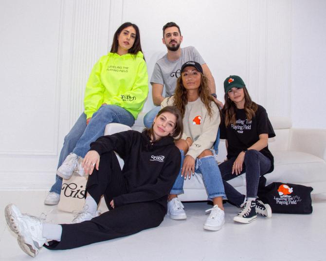 Members of the GIST team post on a white couch in front of a white background in their favorite Capsule Collection gear.
