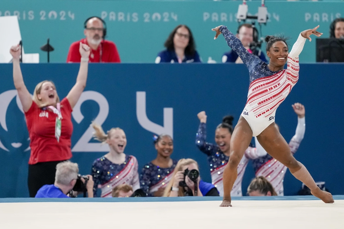 Team USA cheers for Simone Biles during her floor routine.