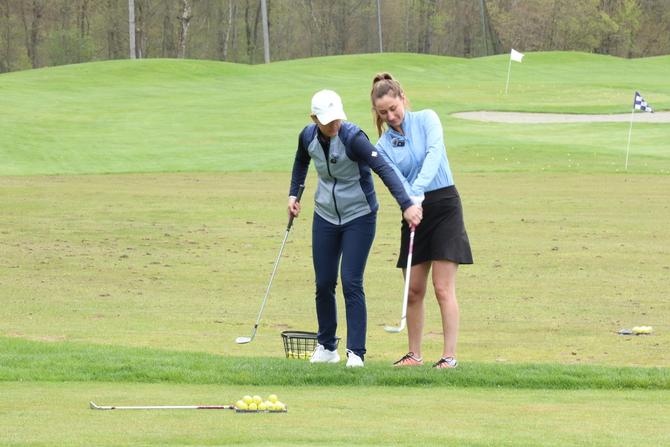 PGA golf pro Emma de Groot helping The GIST co-founder Ellen Hyslop with her golf swing