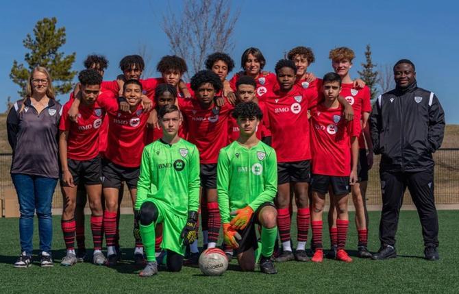 A soccer team posing for a photo on the field