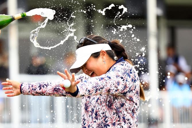 Lilia Vu of the United States is sprayed with champagne in celebration of winning on the number 18 first-playoff hole against Angel Yin of the United States during the final round of The Chevron Championship at The Club at Carlton Woods on April 23, 2023 in The Woodlands, Texas.