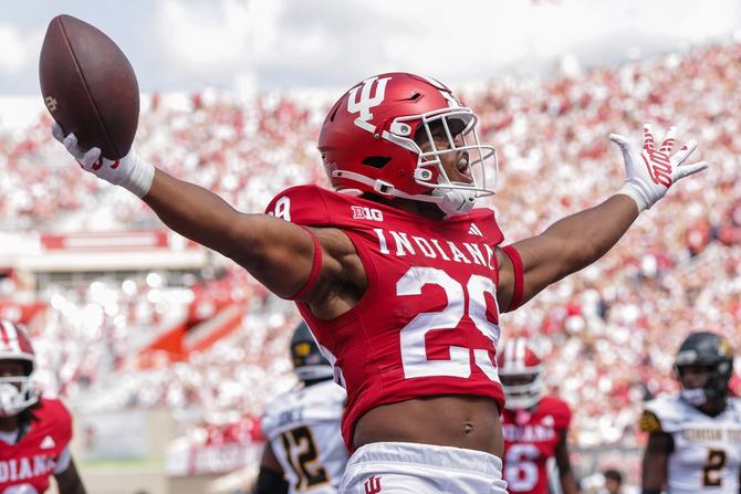 A graphic with several college football players with text reading "Free-to-Play College Football Bracket Challenge".