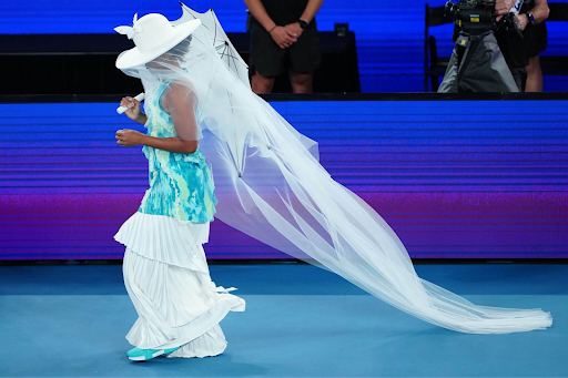 Naomi Osaka walks onto the court in couture.