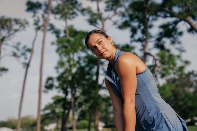 Woman wears Adidas golf apparel.