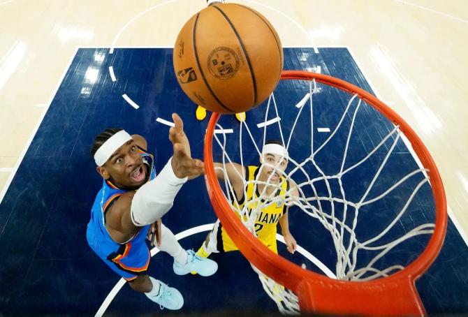 OKC’s Shai Gilgeous-Alexander finished at the rim while Indiana Pacer Andrew Nembhard looks on.