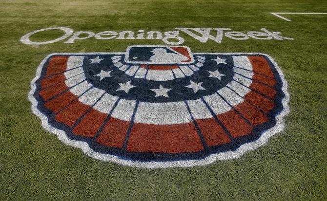 Major League Baseball logo painted on the field with “Opening Week” written above it