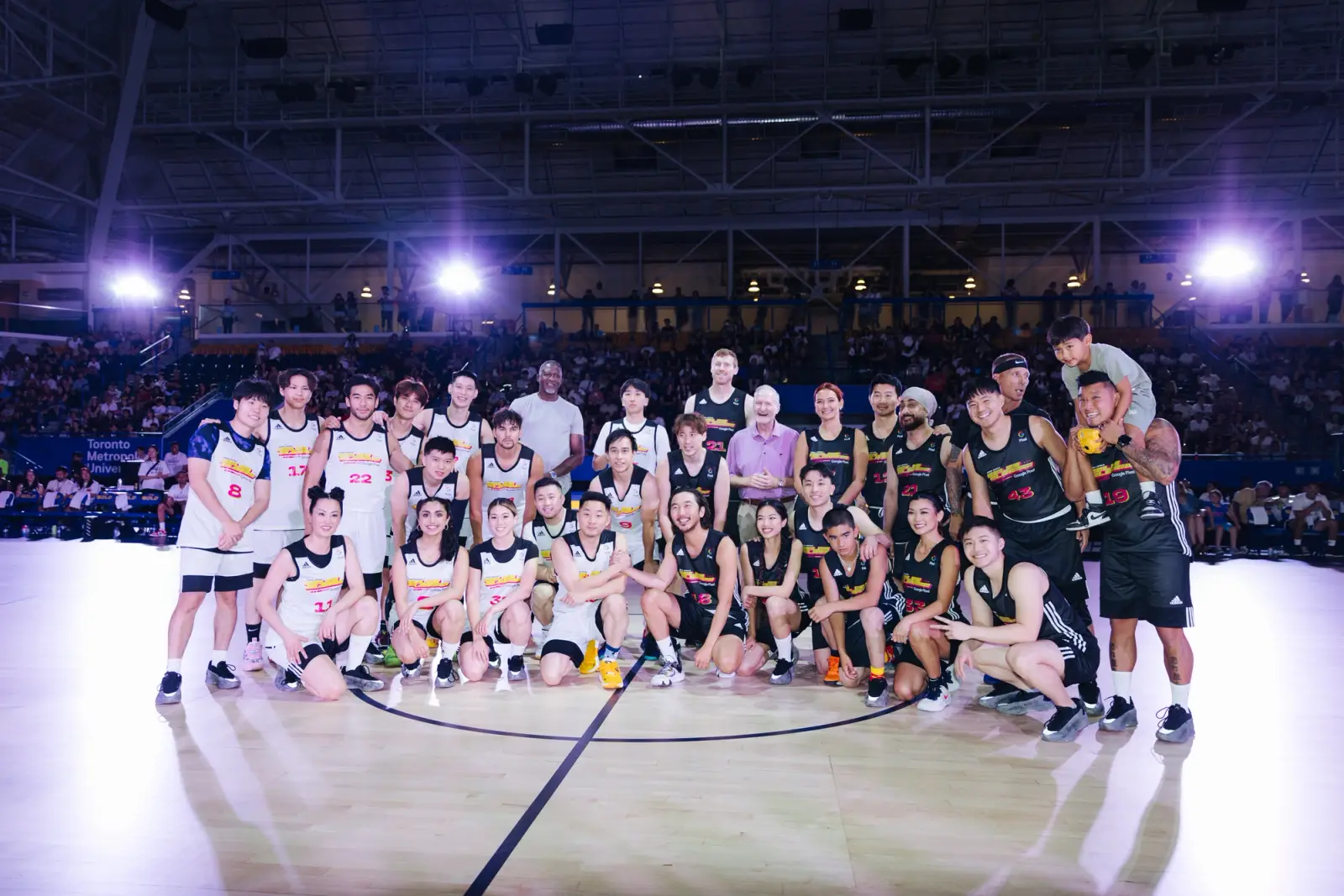 The CCYAA Celebrity Classic Basketball Game participants smiling on the court