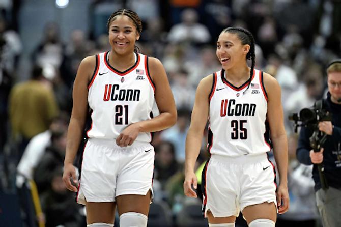 UConn stars Sarah Strong and Azzi Fudd smile as they walk up the court together