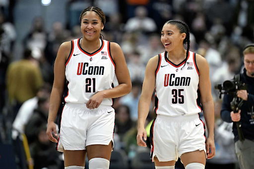 UConn stars Sarah Strong and Azzi Fudd smile as they walk up the court together.