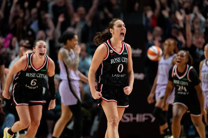 Portland Fire guard Carla Leite celebrates as teammate Bridget Carleton runs towards her.