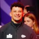 Patrick Mahomes of the Kansas City Chiefs walks across the field smiling during Super Bowl LVIII Opening Night.
