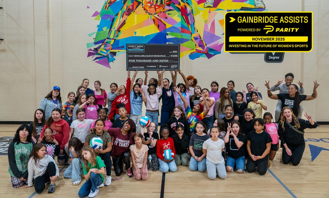 A group of kids smiling while holding a big check
